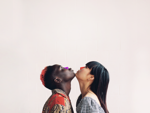 A man and a woman looking up while their chins touch wearing colorful and eco-friendly Nöz sunscreen on their noses. 